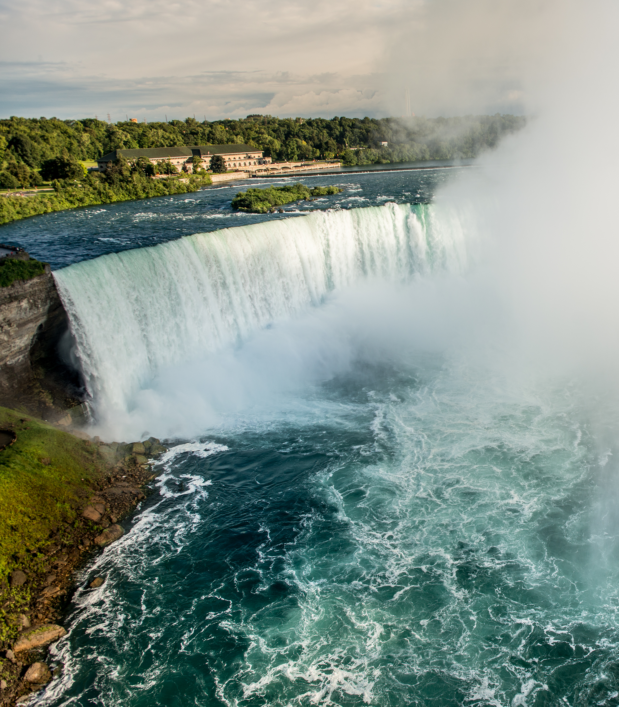 A stunning aerial view of Niagara Falls with mist and cascading water.